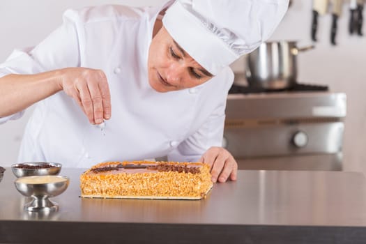 Pastry chef decorating cake yolk and cream