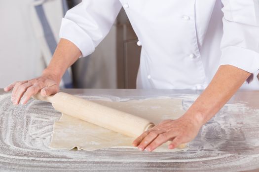 Pastry kneading a dough of a cake
