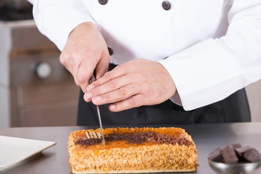 Pastry chef cutting a cake yolk and cream