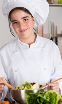 Teen girl in the kitchen preparing a salad