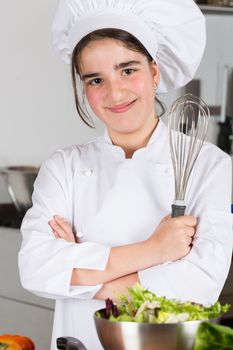 Teen girl in the kitchen preparing a salad
