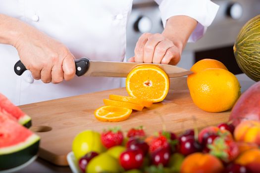 Chef preparing a delicious salad of mixed fruits
