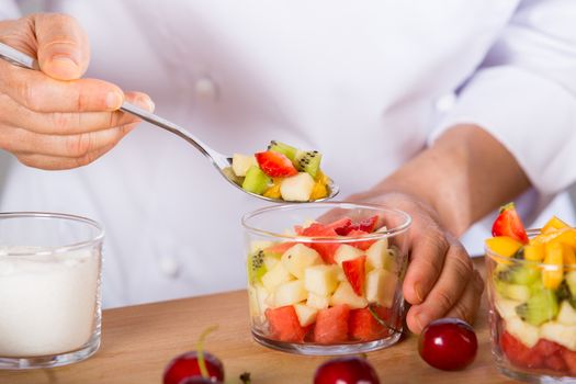 Chef preparing a delicious salad of mixed fruits