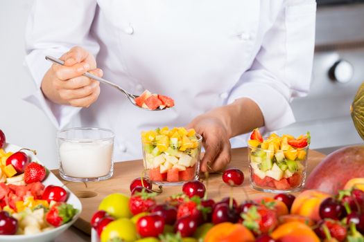 Chef preparing a delicious salad of mixed fruits