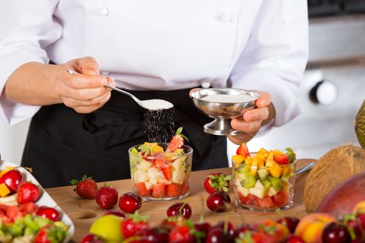 Chef preparing a delicious salad of mixed fruits