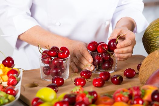 Chef preparing some jars with delicious cherries