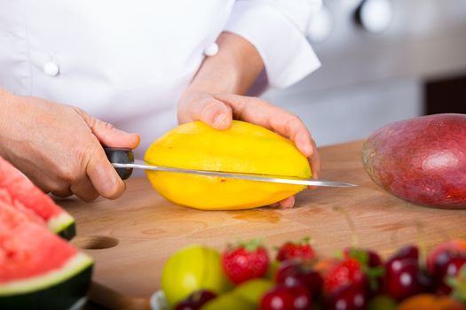 Chef cutting a delicious ripe mango