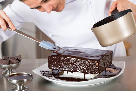 Pastry chef decorating cake yolk and cream