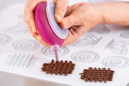 Chef making figures with chocolate to decorate a cake