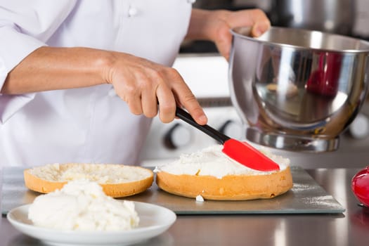 Chef decorating a delicious cake with cream