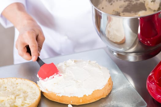 Chef decorating a delicious cake with cream