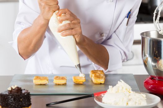 Chef decorating with a pastry bag with cream