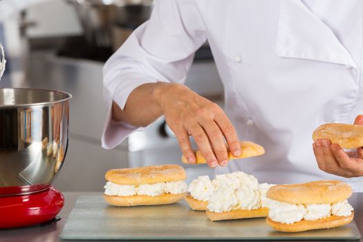 Chef pastry cream filling some biscuits