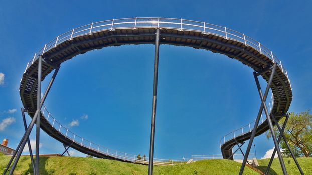 View of a round pedestrian bridge, against a blue sky.Zarasai, Lituania