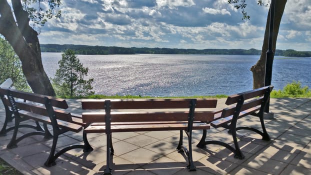 A lonely bench overlooking the lake, on a summer sunny day