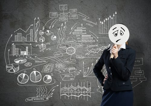 Businesswoman and graphs at background hiding her face behind mask