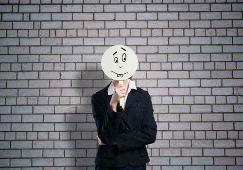 Businesswoman and graphs at background hiding her face behind mask