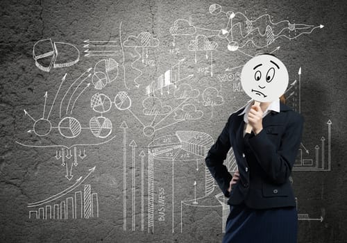 Businesswoman and graphs at background hiding her face behind mask