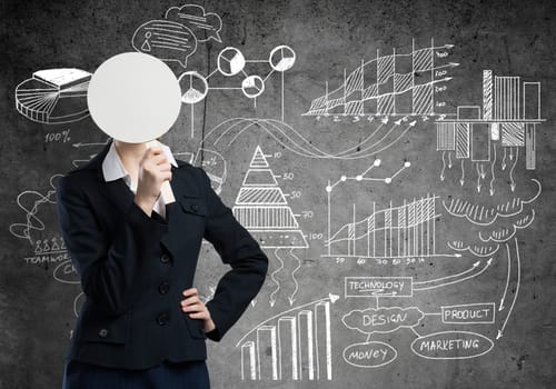 Businesswoman and graphs at background hiding her face behind mask