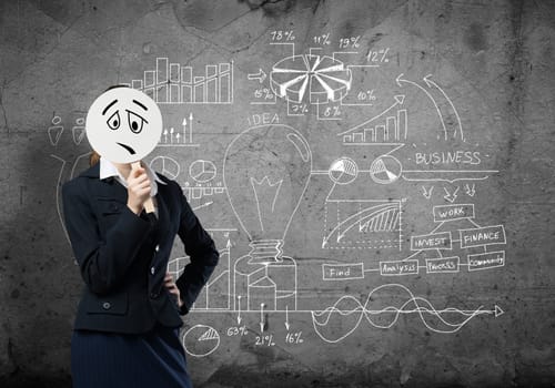 Businesswoman and graphs at background hiding her face behind mask