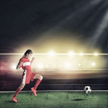 Teenager girl  with the ball at stadium