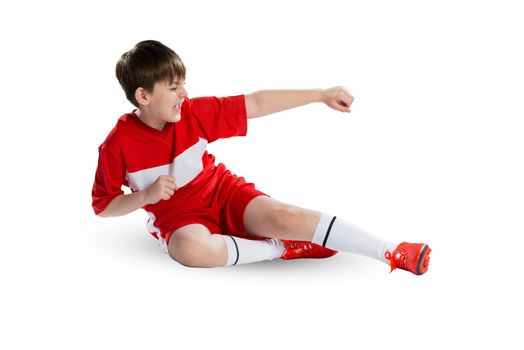 Boy football player in red uniform against white background