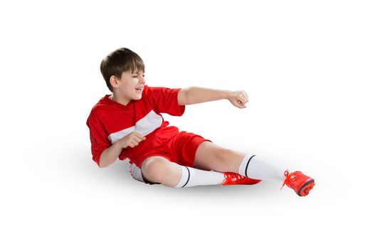 Boy football player in red uniform against white background