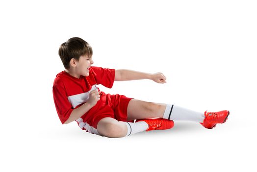 Boy football player in red uniform against white background