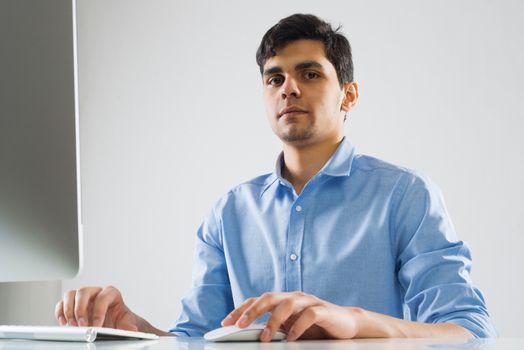 Young man sitting at desk and working on computer