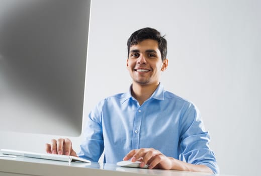 Young man sitting at desk and working on computer