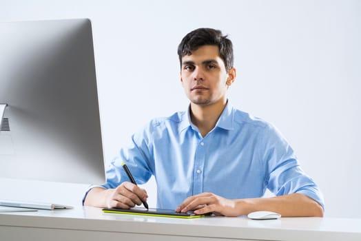 Young man sitting at desk and working on computer