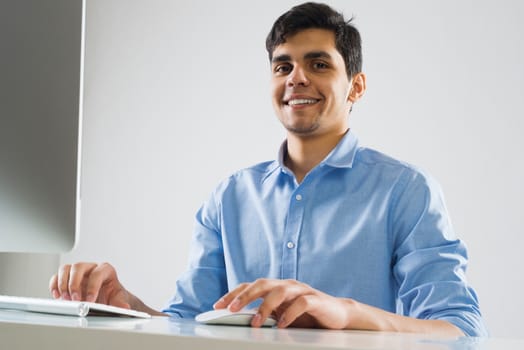 Young man sitting at desk and working on computer