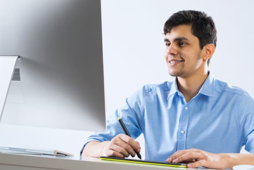 Young graphic designer sitting at desk and working