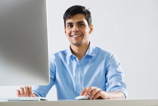 Young man sitting at desk and working on computer