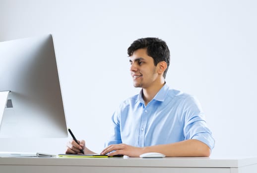 Young graphic designer sitting at desk and working
