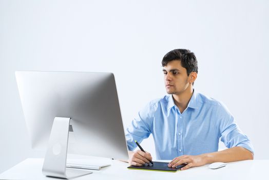 Young graphic designer sitting at desk and working