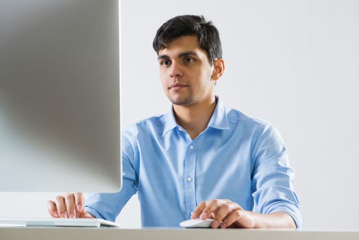 Young man sitting at desk and working on computer