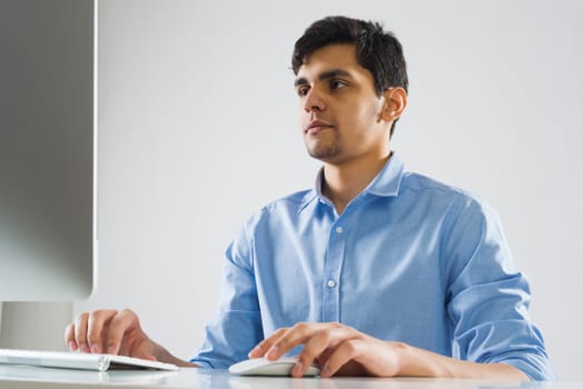 Young man sitting at desk and working on computer