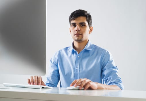 Young man sitting at desk and working on computer