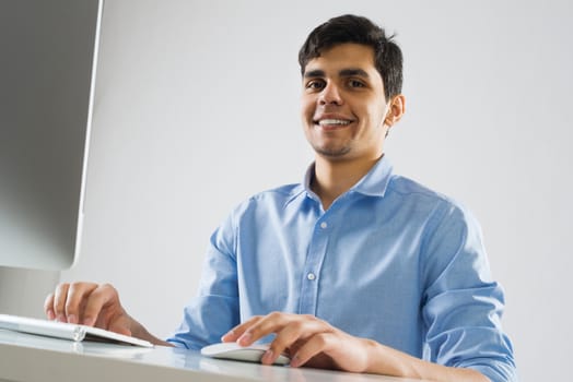 Young man sitting at desk and working on computer