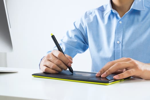 Young graphic designer sitting at desk and working