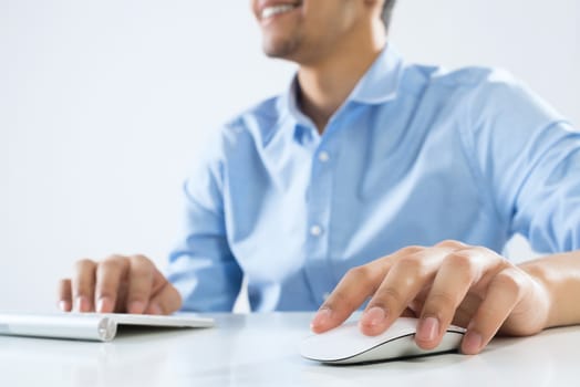 Young man sitting at desk and typing on keyboard