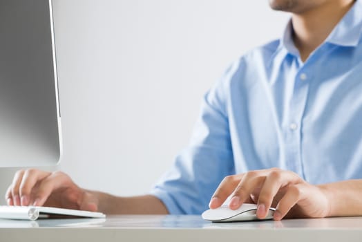 Young man sitting at desk and typing on keyboard