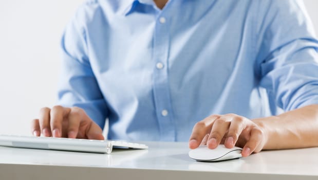 Young man sitting at desk and typing on keyboard