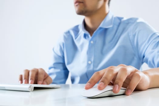 Young man sitting at desk and typing on keyboard