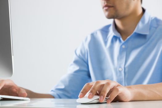 Young man sitting at desk and typing on keyboard