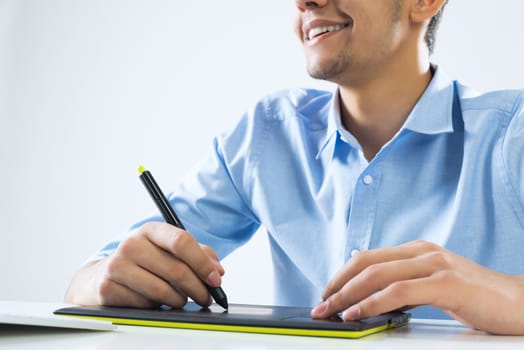 Young graphic designer sitting at desk and working