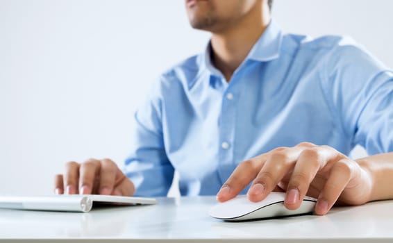 Young man sitting at desk and typing on keyboard