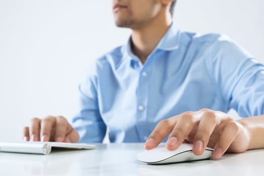 Young man sitting at desk and typing on keyboard