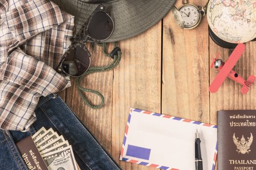 jeans, shirt, passports, banknote, sunglasses, airplane model, pocket watch, fountain pen and envelope of cost of travel prepared for the trip, Travel accessorie costumer, vintage filter